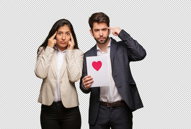 Pareja joven en el día de san valentín haciendo un gesto de concentración