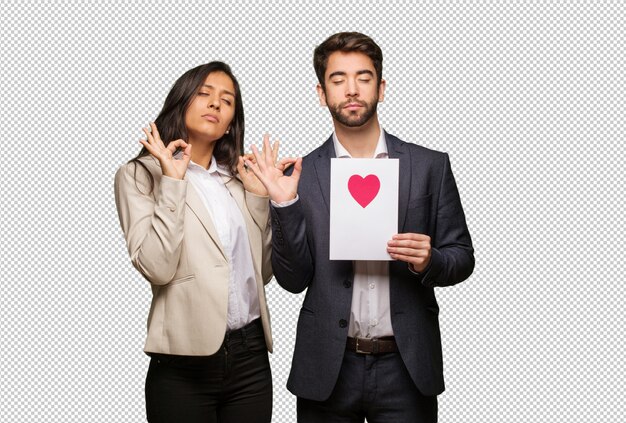 Pareja joven en el día de San Valentín realizando yoga