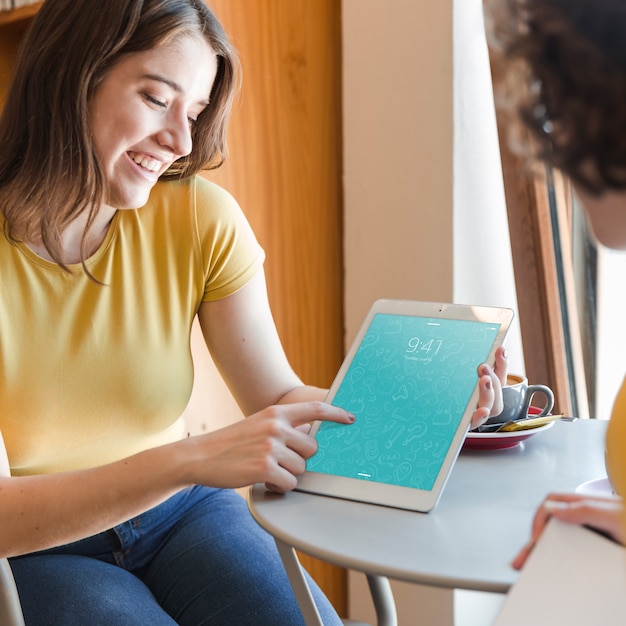 Pareja con mockup de tablet en biblioteca