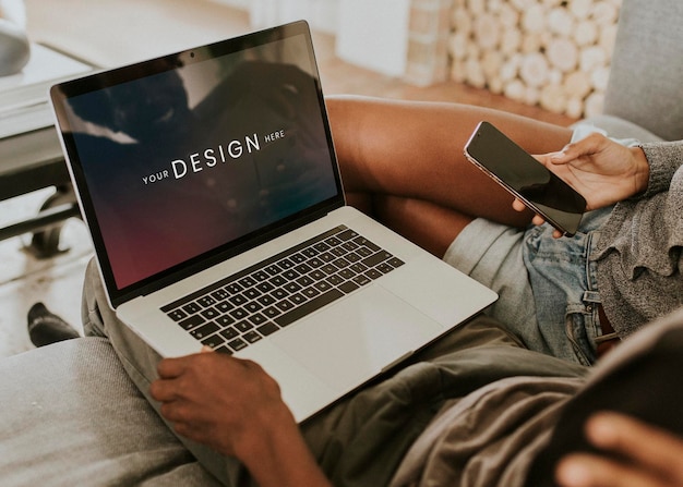 Una pareja negra usando una computadora portátil y una maqueta de pantalla móvil