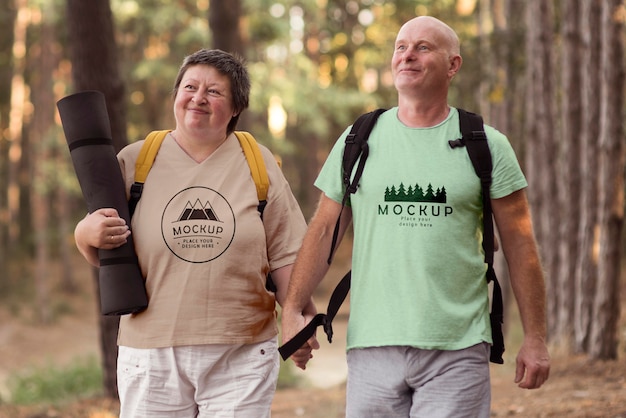 Pareja senior en camping con una camiseta de maqueta