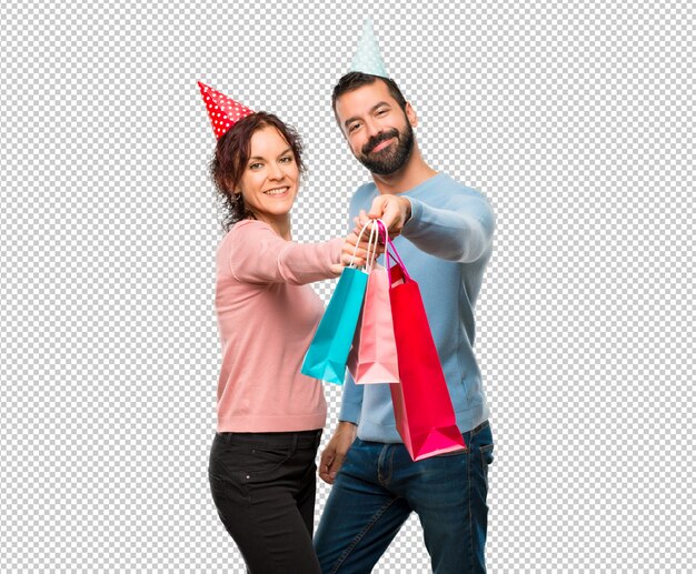 PSD pareja con sombreros de cumpleaños y con bolsas de compras