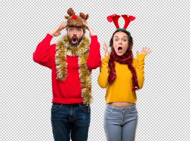 Pareja vestida para las fiestas navideñas con sorpresa y expresión facial conmocionada.