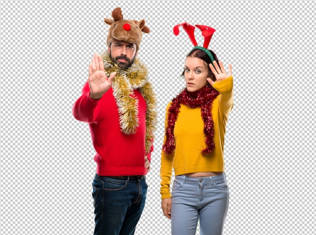 PSD pareja vestida para las vacaciones de navidad haciendo gesto de parada con su mano