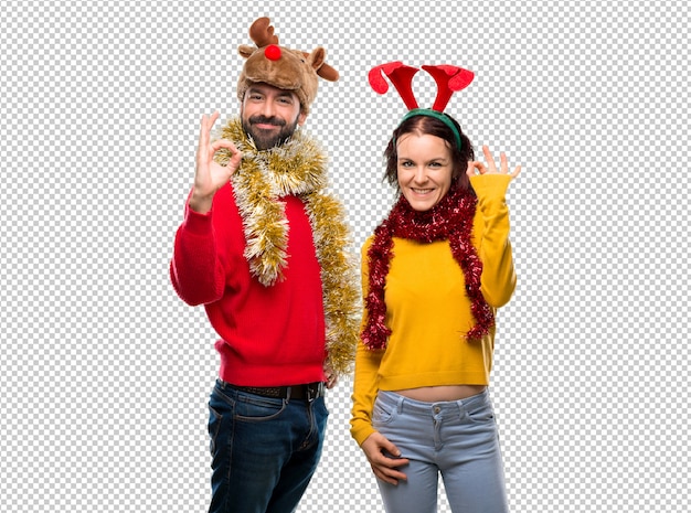 PSD pareja vestida para las vacaciones de navidad mostrando un signo ok con los dedos