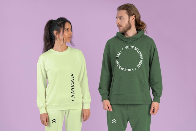 Pareja vistiendo pantalones jogger y maqueta de sudadera con capucha