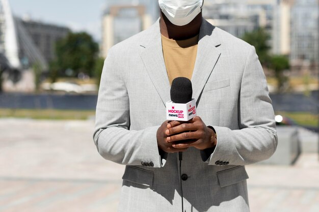 Periodista sosteniendo una maqueta de micrófono