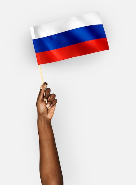 Person, die die Flagge der Russischen Föderation wellenartig bewegt