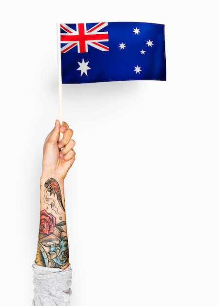 Person, die die flagge des commonwealth von australien wellenartig bewegt