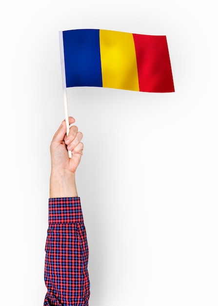 Person, die die Flagge von Rumänien wellenartig bewegt