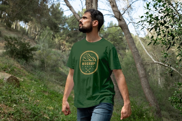 Person, die draußen in der Natur ein Mock-up-T-Shirt trägt