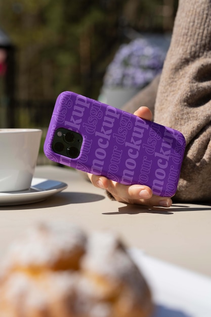 Person, die draußen Smartphone-Attrappe hält