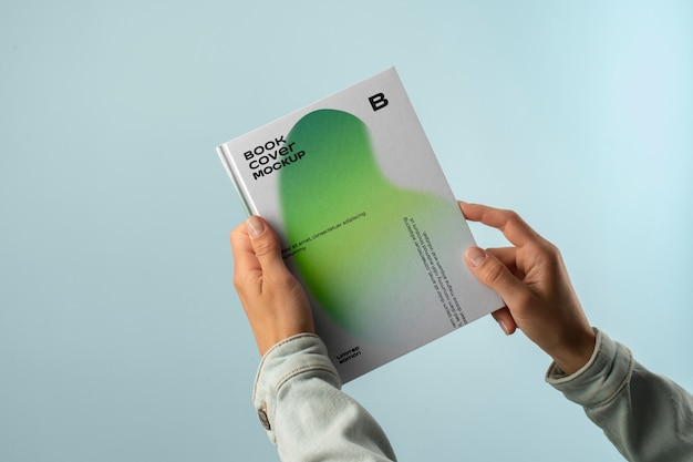 Person, die ein Buch mit hartem Cover in den Händen hält