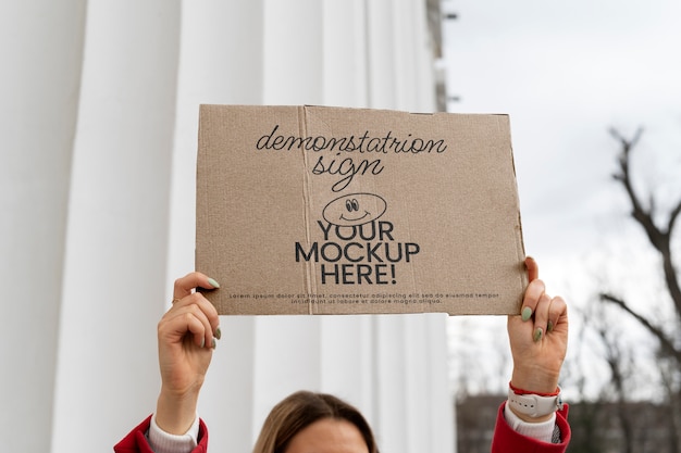 Person hält bei protest ein schild mit einer attrappe