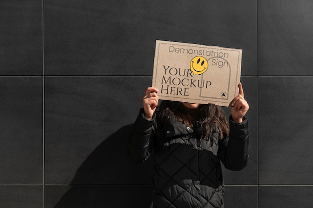 Person hält bei protest ein schild mit einer attrappe