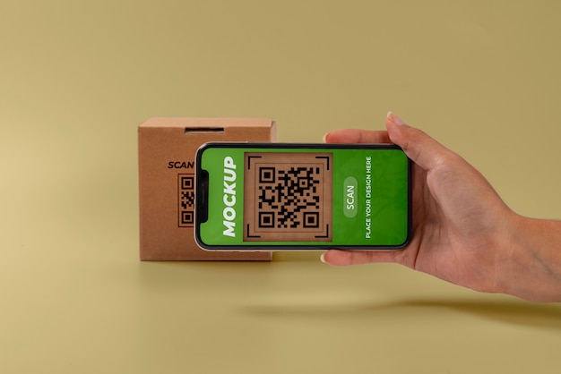 Person scannt qr-code auf karton mit smartphone