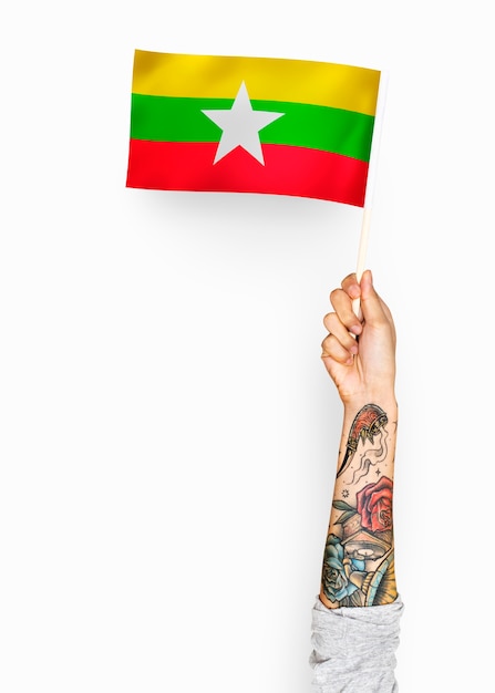 Person weht die flagge der republik der union von myanmar