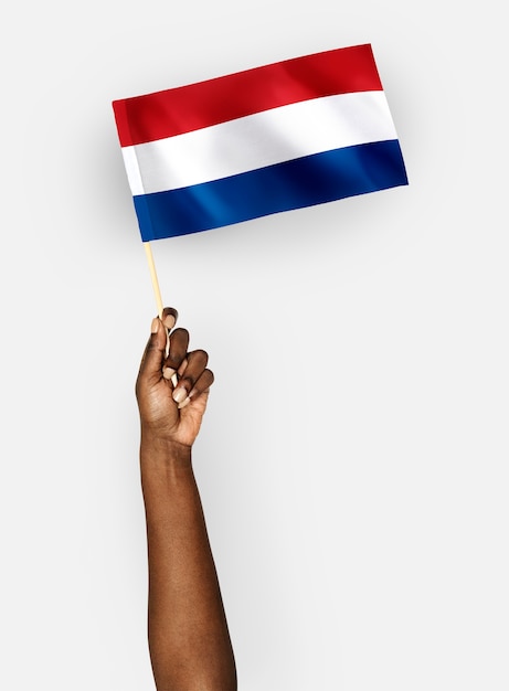 Person winkt die flagge der niederlande