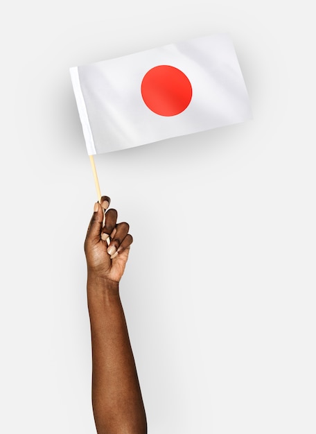 Persona che sventola la bandiera del Giappone