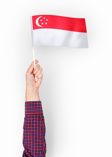 Persona que agita la bandera de la república de singapur