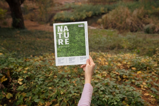 Persona con revista de papel al aire libre en la naturaleza
