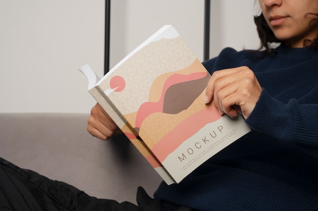 Personne tenant et lisant un livre à la maison