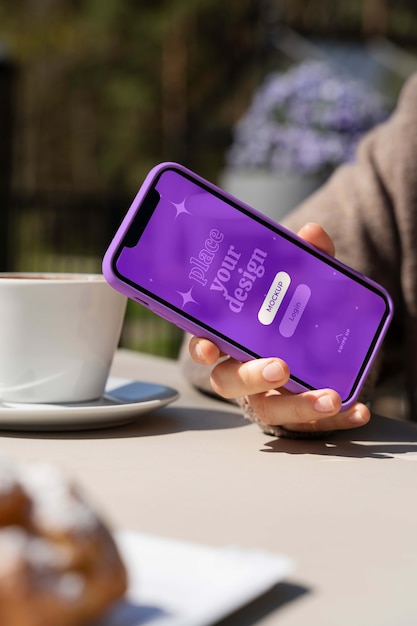 Personne tenant une maquette de smartphone à l'extérieur