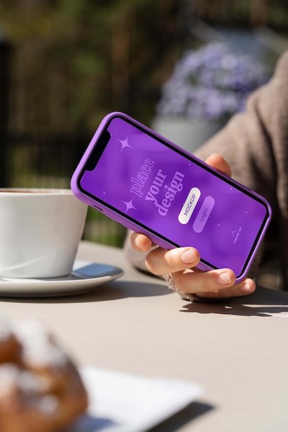 PSD personne tenant une maquette de smartphone à l'extérieur