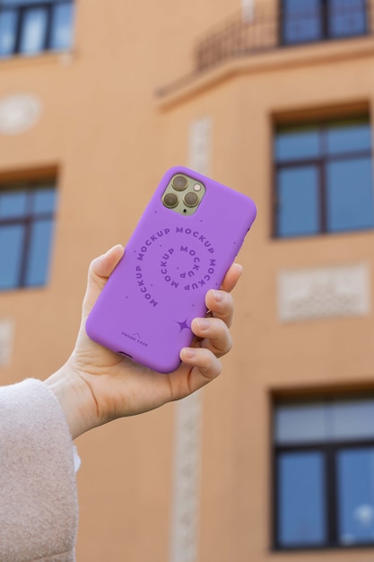 Personne tenant une maquette de smartphone à l'extérieur