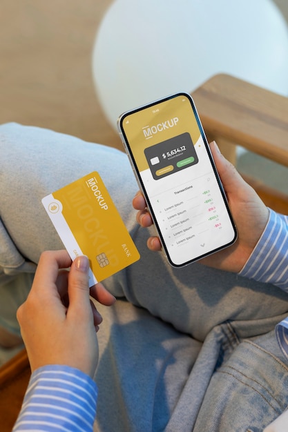 Personne utilisant une maquette de carte de crédit avec un smartphone