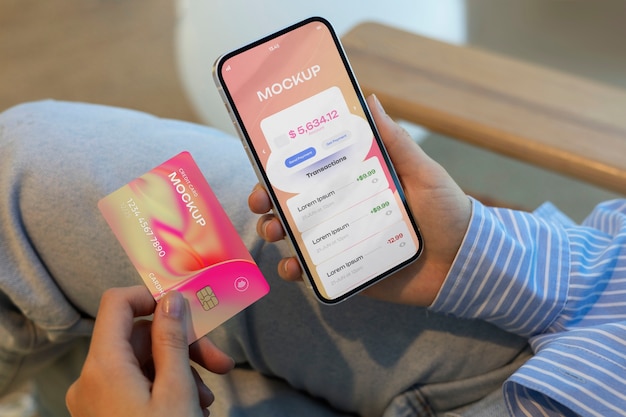 Personne utilisant une maquette de carte de crédit avec un smartphone
