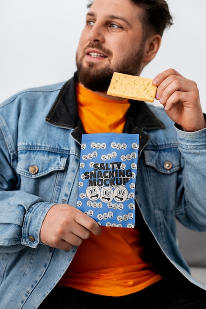 Pessoa desfrutando de um lanche salgado com embalagem simulada