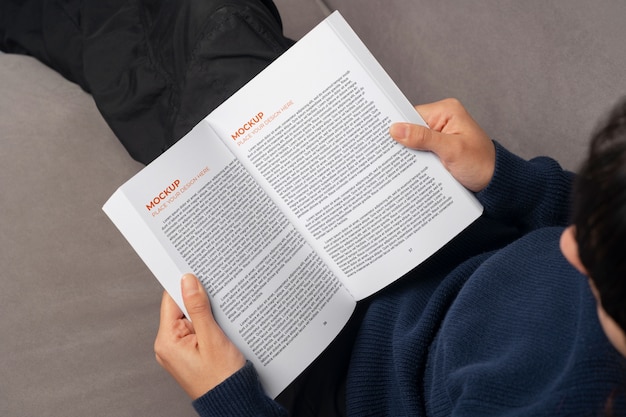 Pessoa segurando e lendo um livro em casa