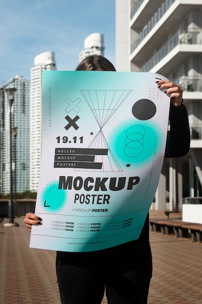 Pessoa segurando um modelo de cartaz ao ar livre