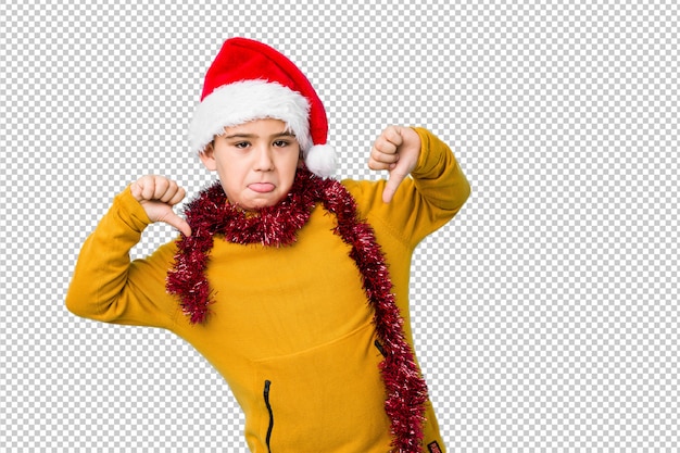 Petit garçon célébrant le jour de Noël portant un bonnet de Noel isolé se sent fier et confiant, exemple à suivre.