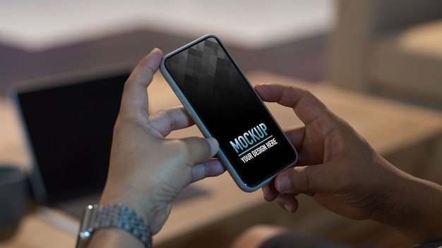 Une photo coupée de mains masculines à l'aide d'un modèle de smartphone