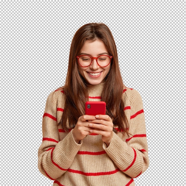 Photo intérieure d'une adolescente satisfaite. Textes sur son téléphone portable. Lire un article intéressant en ligne. Porte une tenue décontractée. Crée une nouvelle publication sur sa propre page Web. Isolé sur un mur brun avec de l'espace libre.