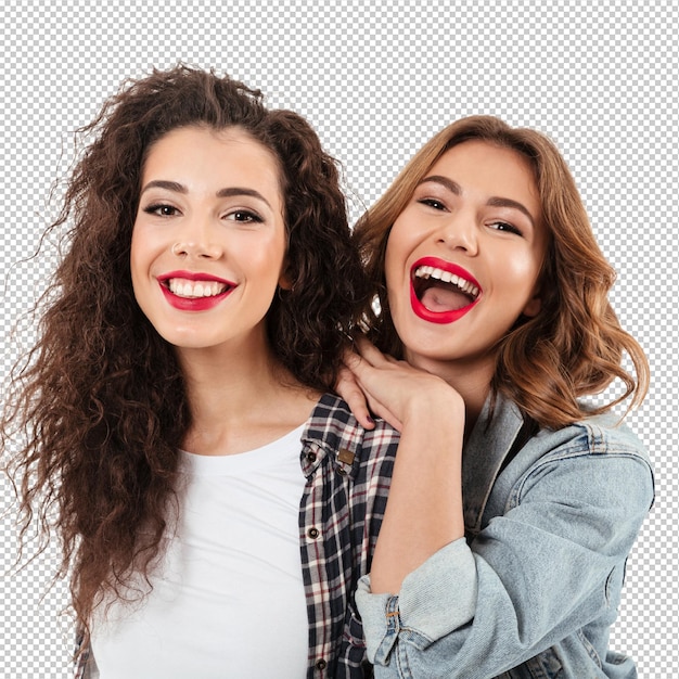 Une photo rapprochée de deux filles joyeuses posant ensemble sur un mur blanc