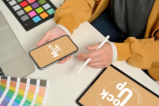 PSD photo recadrée de mains de concepteur féminin travaillant avec un smartphone