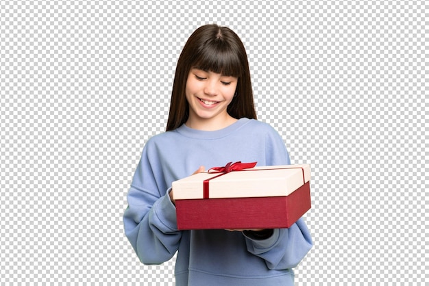 Piccola ragazza che tiene un regalo su uno sfondo a chiave cromatica isolato con un'espressione felice