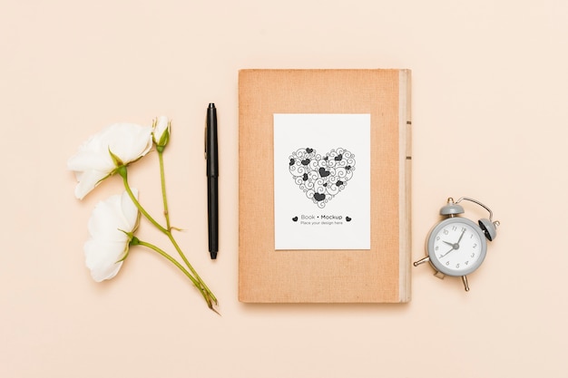 Plano de libro con reloj y rosas