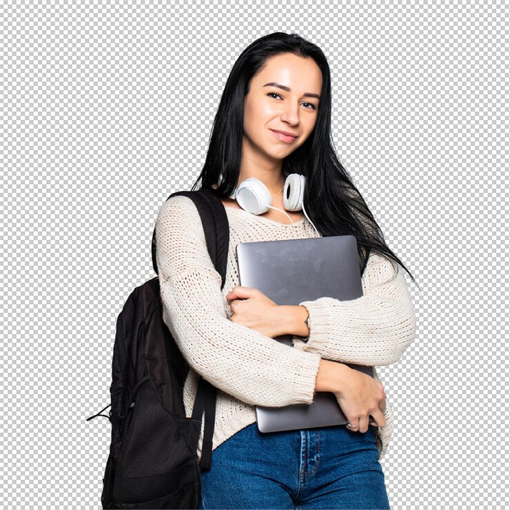 PSD portrait of a smiling young woman standing with laptop against gray wall