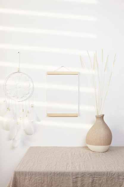 Posterhänger-Mockup an der Wand mit beigefarbener Vase