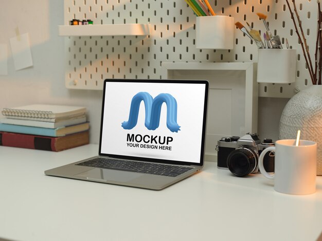 Posto di lavoro con laptop mockup, cancelleria, libri e decorazioni