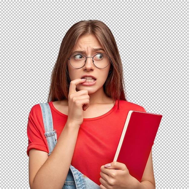 Preocupada, ansiosa, jovem, mantém o dedo indicador perto da boca, olha desesperadamente para um lado, usa óculos redondos, carrega modelos de livros vermelhos contra a parede branca, espaço livre para a sua promoção.