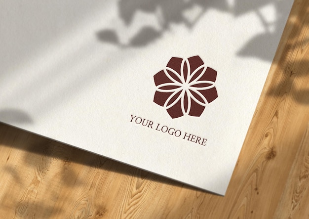 Presentazione del mockup del logo su carta e sfondo in legno