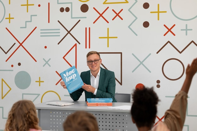 Professor hält ein Modell von Unterrichtsmaterialien in der Hand