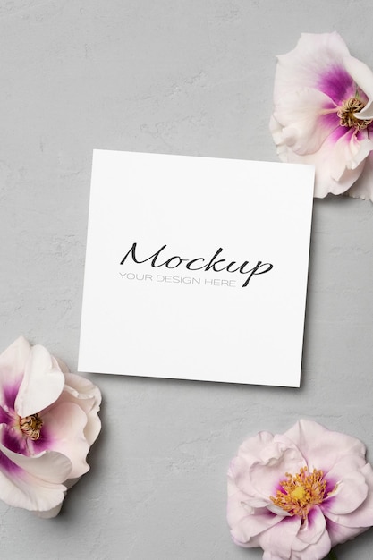 Quadratisches Papierkarten-Mockup mit Blumen, flach gelegt mit Kopierplatz