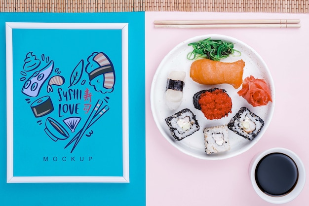 Rám vedle talíře se sushi rolkami a sójovou omáčkou