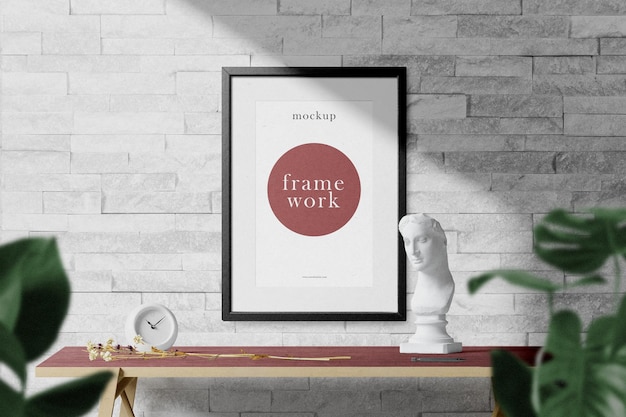 Reinigen Sie das minimale Rahmenmodell an der Wand mit Desktop und Blättern